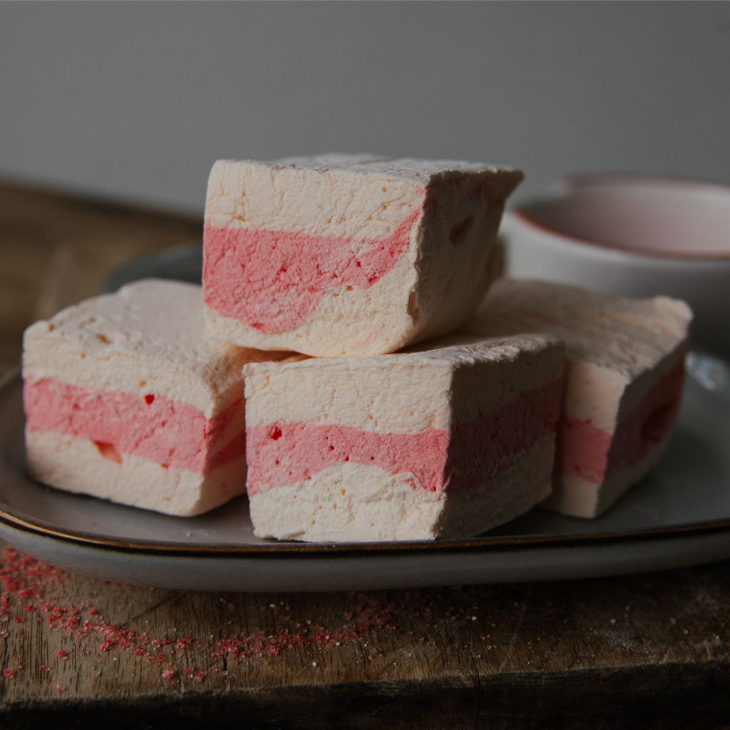 Stack of layered marshmallows on a plate with a blurred background