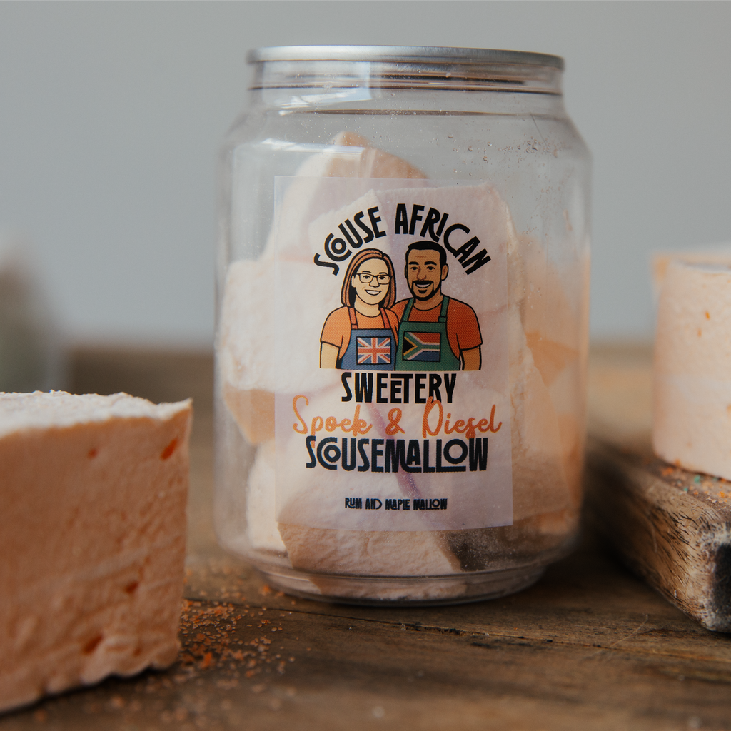 Can of marshmallows with a label featuring two people and text, on a wooden surface.